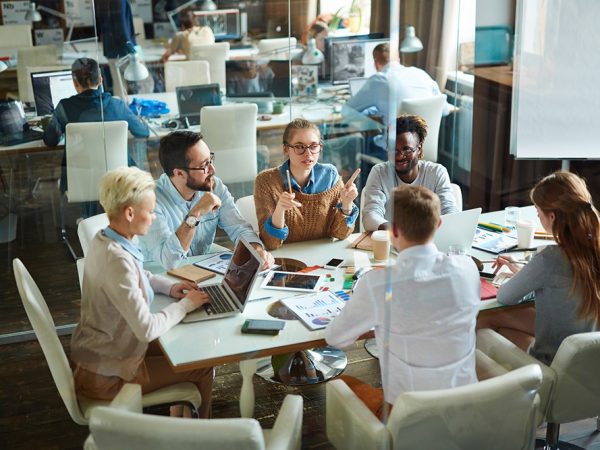 Group of modern employees gathered for meeting in office